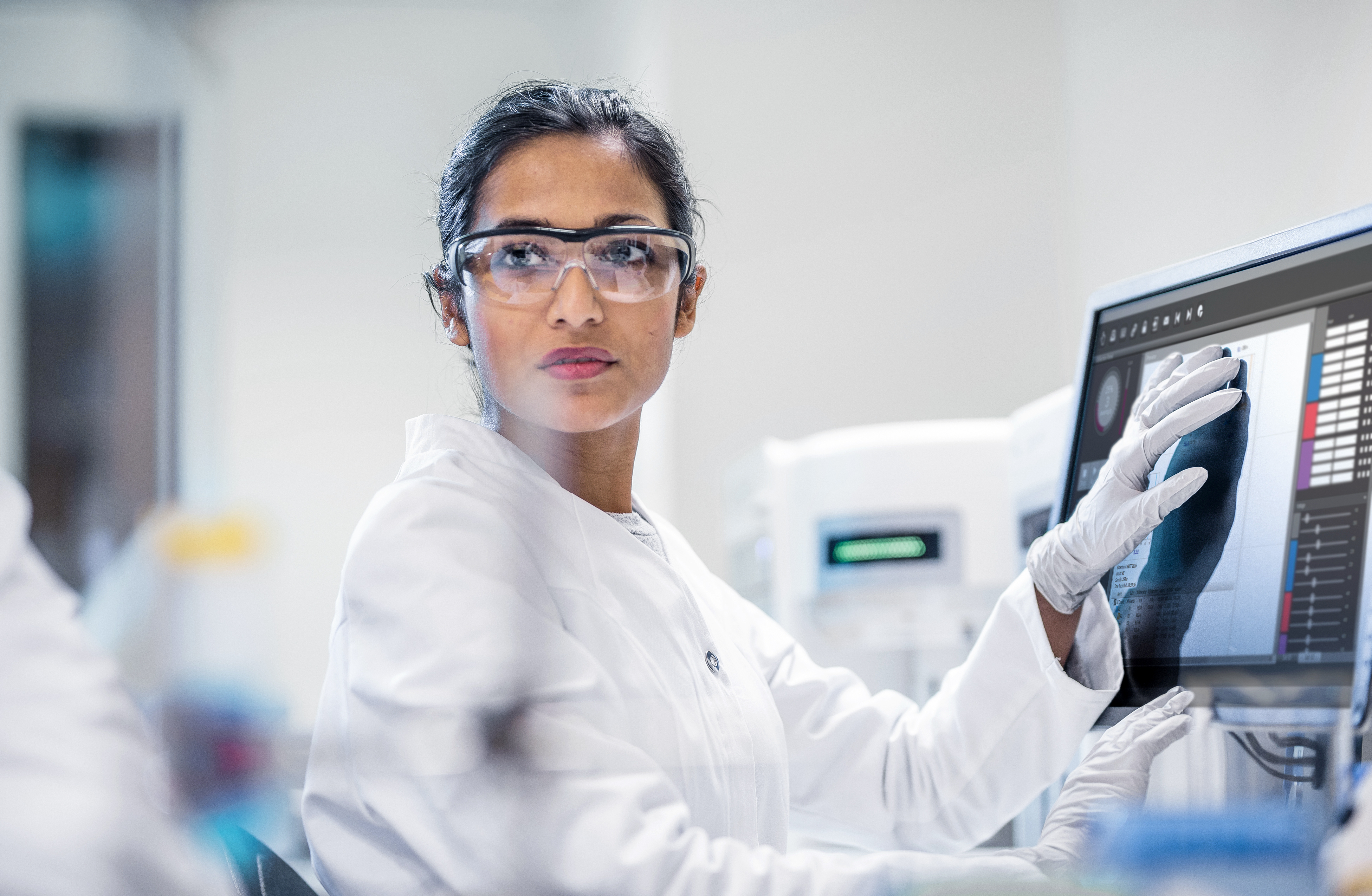 Scientist Analyzing Data in a Modern Lab Scientist in a lab coat analyzing data on a computer in a laboratory